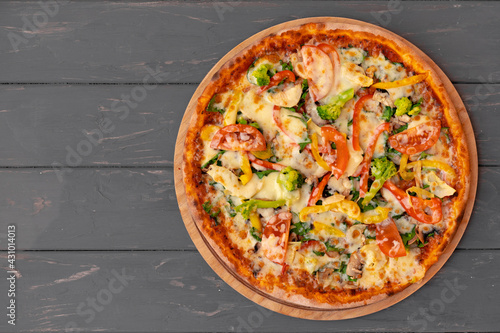 Delicious pizza on gray wooden background top view