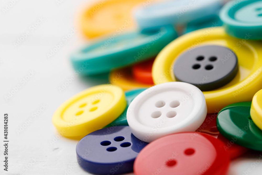 Close up of pile of colorful buttons on white background Close up of pile of colorful buttons on white background