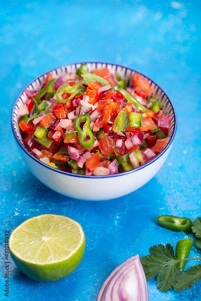 Homemade salsa pico de gallo, mexican cuisine, blue background Homemade salsa pico de gallo, mexican cuisine, blue background