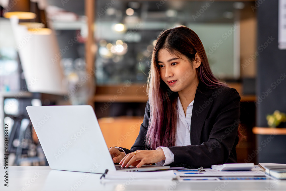 Portrait of Business young woman working on laptop computer doing finances,accounting analysis,report,data and pointing graph at the office. Portrait of Business young woman working on laptop computer doing finances,accounting analysis,report,data and pointing graph at the office.