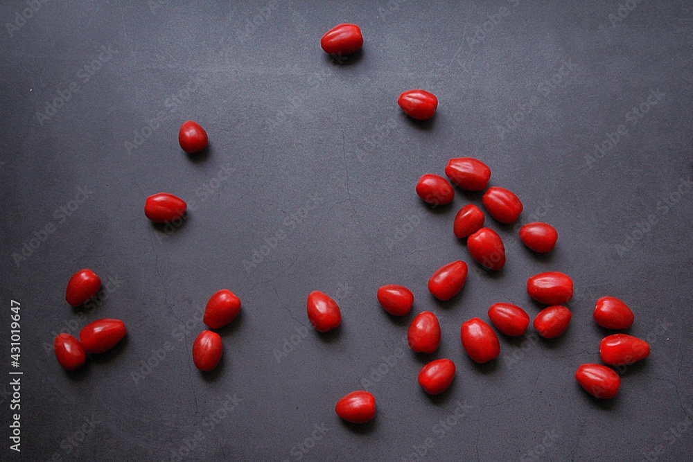 scattered small tomatoes on a dark background, red ripe tomatoes, vegetables scattered small tomatoes on a dark background, red ripe tomatoes, vegetables