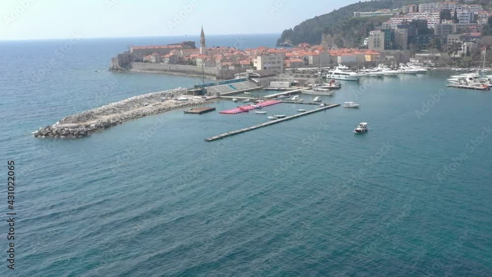 Aerial view of ancient Balkan's town and marina with boats and yachts. Helicopter is flying around the promenade and marina in a semicircle Aerial view of ancient Balkan's town and marina with boats and yachts. Helicopter is flying around the promenade and marina in a semicircle