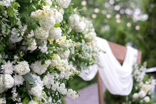 Close up of arch for the wedding ceremony, decorated with cloth and white flowers