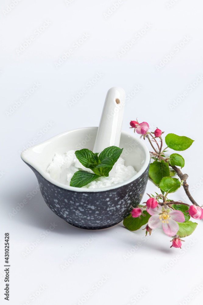 cosmetic cream in a bowl with pestle and aromatic herbs cosmetic cream in a bowl with pestle and aromatic herbs