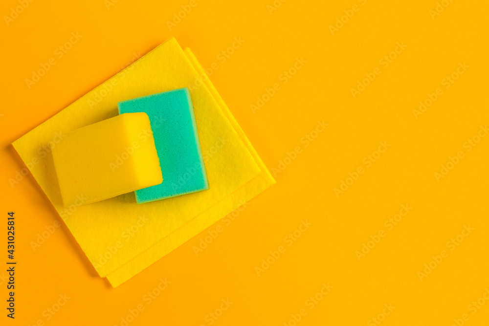 Yellow and blue cleaning sponge on yellow background with copy space. Household chores or house cleaning services. Cleaning products concept. Yellow and blue cleaning sponge on yellow background with copy space. Household chores or house cleaning services. Cleaning products concept.