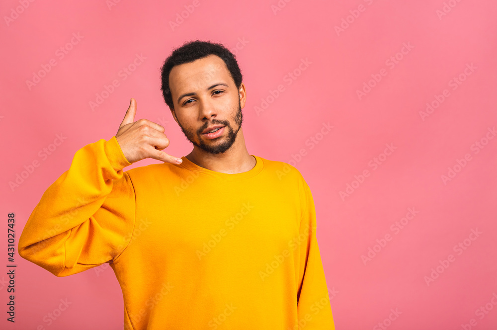 Call me sign. Portrait of a happy african american guy talking on mobile phone isolated against pink background. Call me sign. Portrait of a happy african american guy talking on mobile phone isolated against pink background.