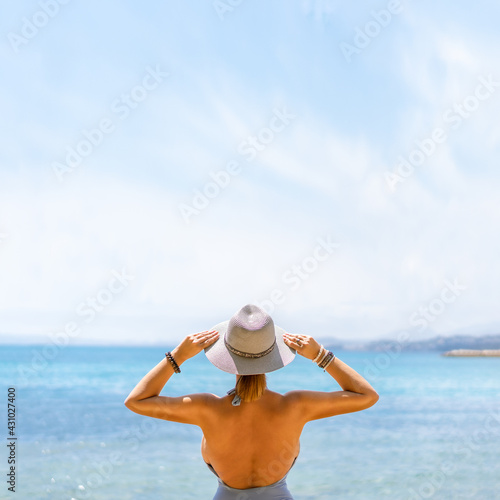 Happy woman enjoying beach relaxing joyful in summer by tropical blue water.