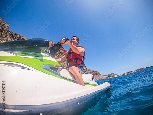 Young boy enjoy jet sky tour excursion activity water sport and smile - people tourist have fun - blue ocean active male in summer holiday vacation