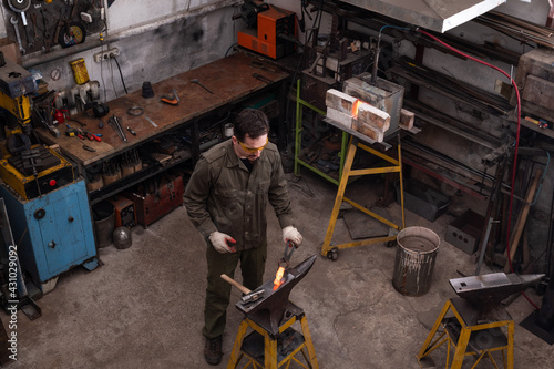 The master blacksmith works in the workshop. Top view.