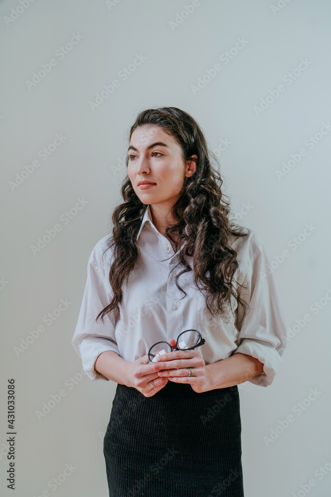 Portrait of confident young businesswoman standing near the light wall Portrait of confident young businesswoman standing near the light wall
