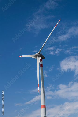 Wind turbine that stand out against the blue summer sky of the Tuscan countryside