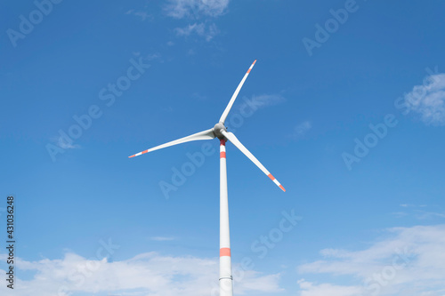 Wind turbine that stand out against the blue summer sky of the Tuscan countryside