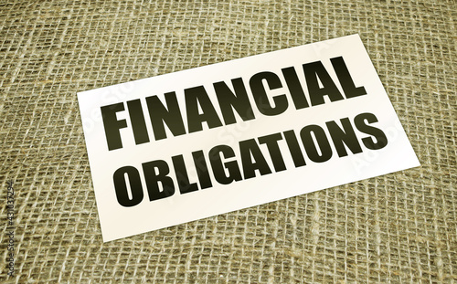 Financial Obligation words on card on burlap canvas. Business debts concept