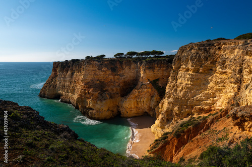 View of a small secluded beach surrounded by cliffs in Algarve, Portugal