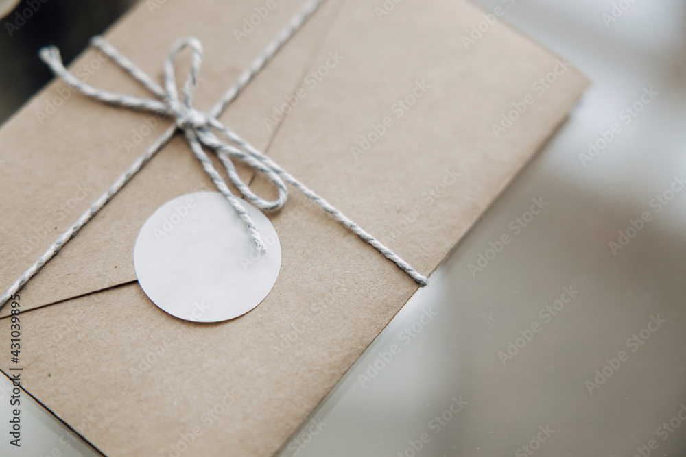 Craft paper envelope tied with a rope. Blank paper sticker to copy space your personal logo. Wedding invitations on the table. Craft paper envelope tied with a rope. Blank paper sticker to copy space your personal logo. Wedding invitations on the table.