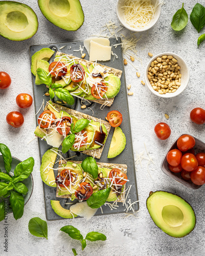 crispbread with avocado, tomatoes and basil and parmesan photo