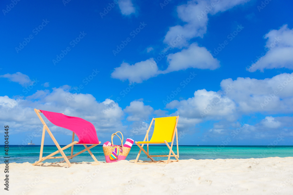 Colorful beach lounge chairs and beach bag at the beach Colorful beach lounge chairs and beach bag at the beach