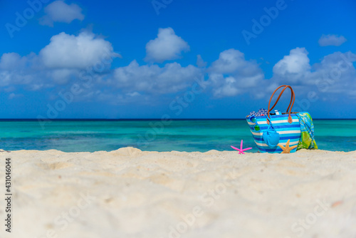 Colorful beach bag with sunglasses  towel  bikini and flip flops at the beach