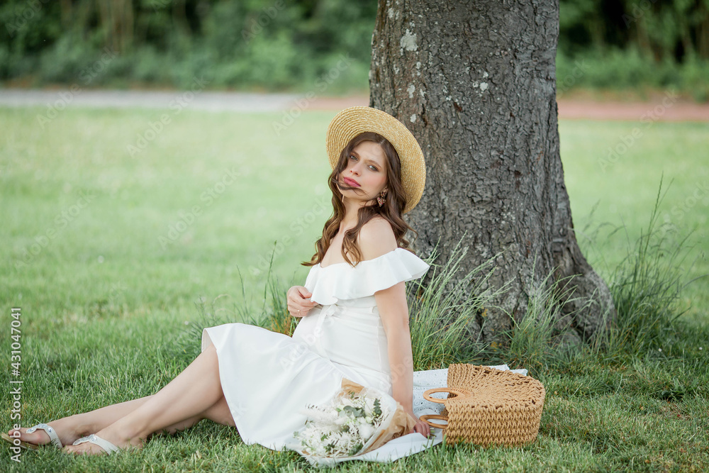 Obraz premium Portrait of a beautiful young pregnant woman in nature. Happiness.