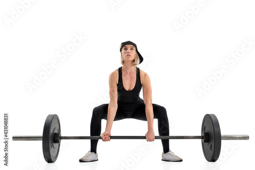 Young woman doing deadlift with a barbell isolated on white