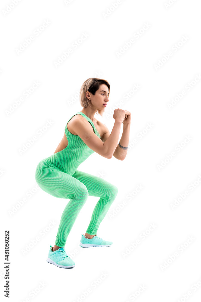 Obraz premium Studio shot of an athletic woman doing squats isolated over whit