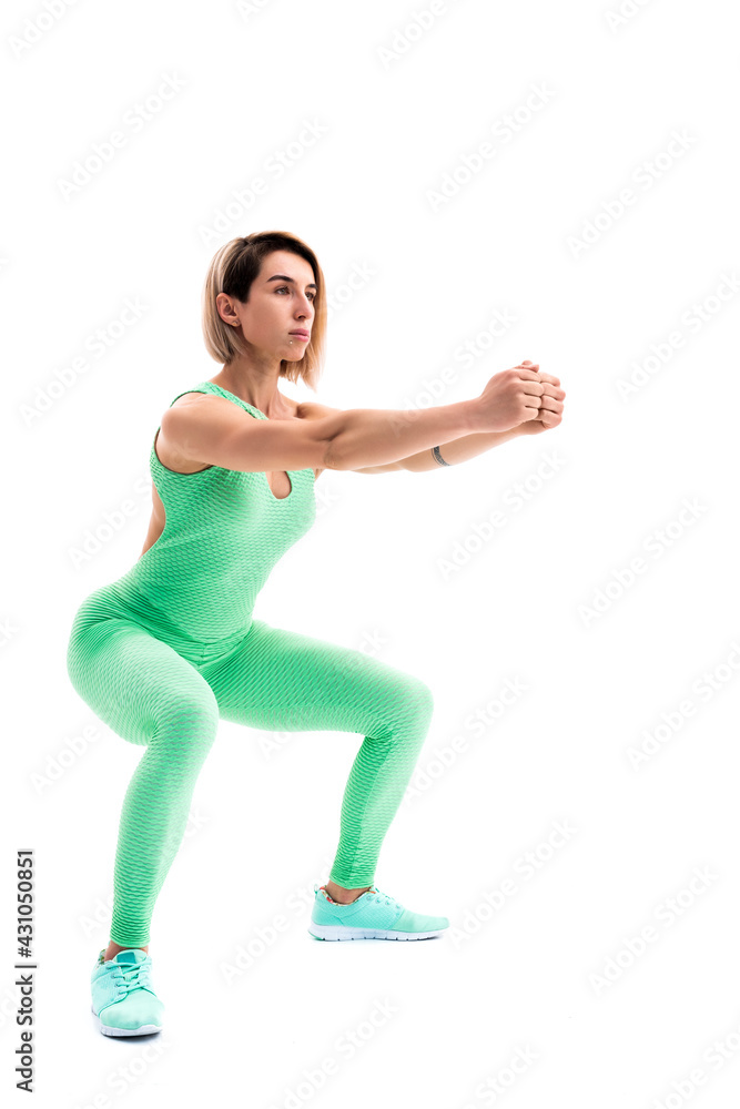 Obraz premium Studio shot of an athletic woman doing squats isolated over whit