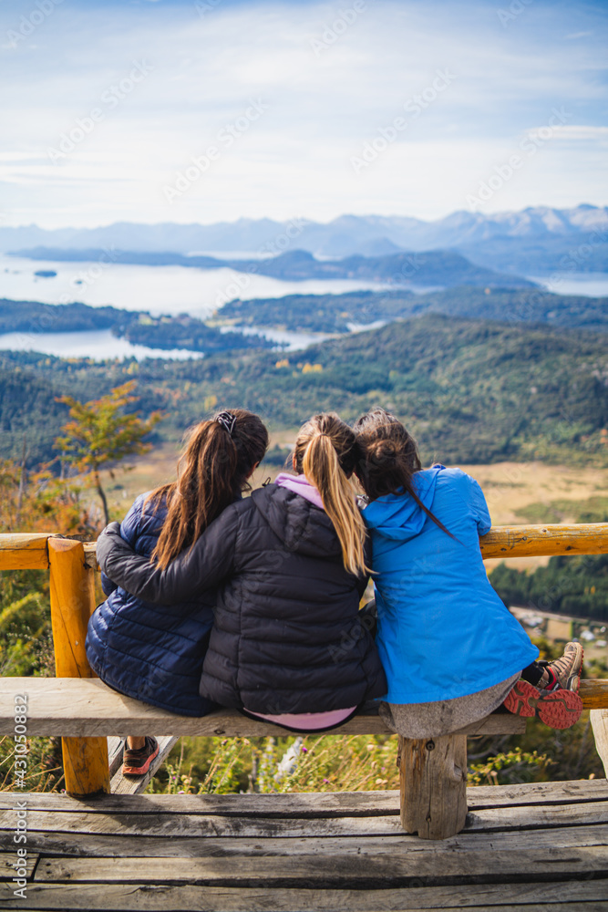 Three young women at lookout point in the middle of the forest in the mountains of Patagonia Argentina Lago Bariloche Three young women at lookout point in the middle of the forest in the mountains of Patagonia Argentina Lago Bariloche