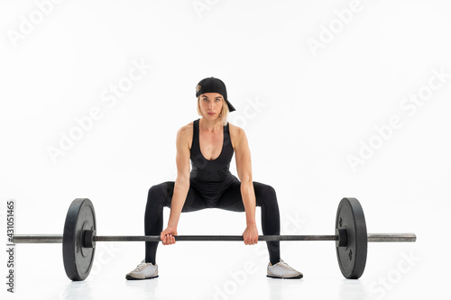 Young woman doing deadlift with a barbell isolated on white