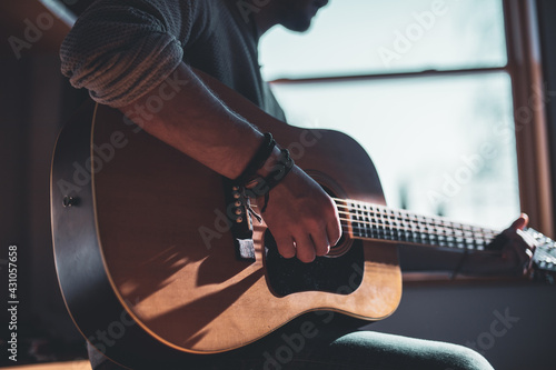 Musician playing on acoustic guitar