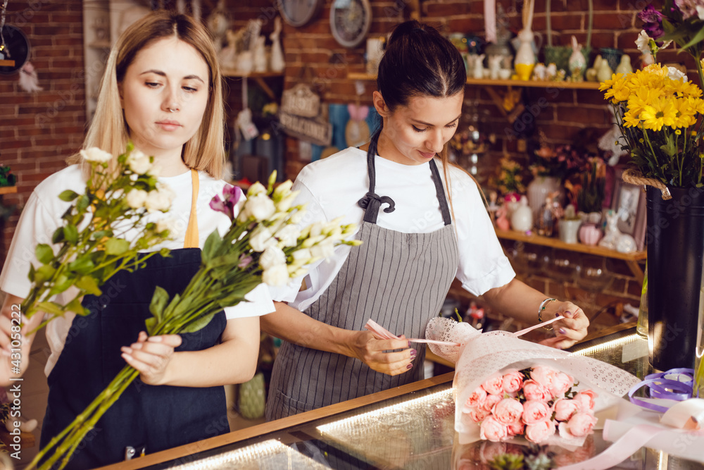 Women florists collect bouquets of flowers at their desk in a flower shop. Women florists collect bouquets of flowers at their desk in a flower shop.