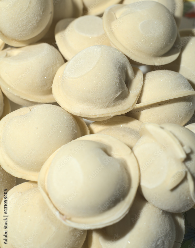Raw frozen dumplings. Closeup. Vertical snapshot