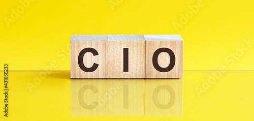 cio word is made of wooden building blocks lying on the yellow table, concept