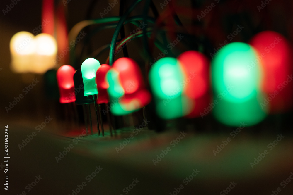 blurred closeup of LED elements on electronic board in white green red