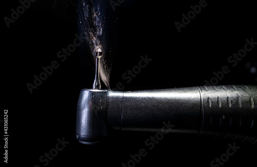 A dental drill or handpiece with burr sprays water