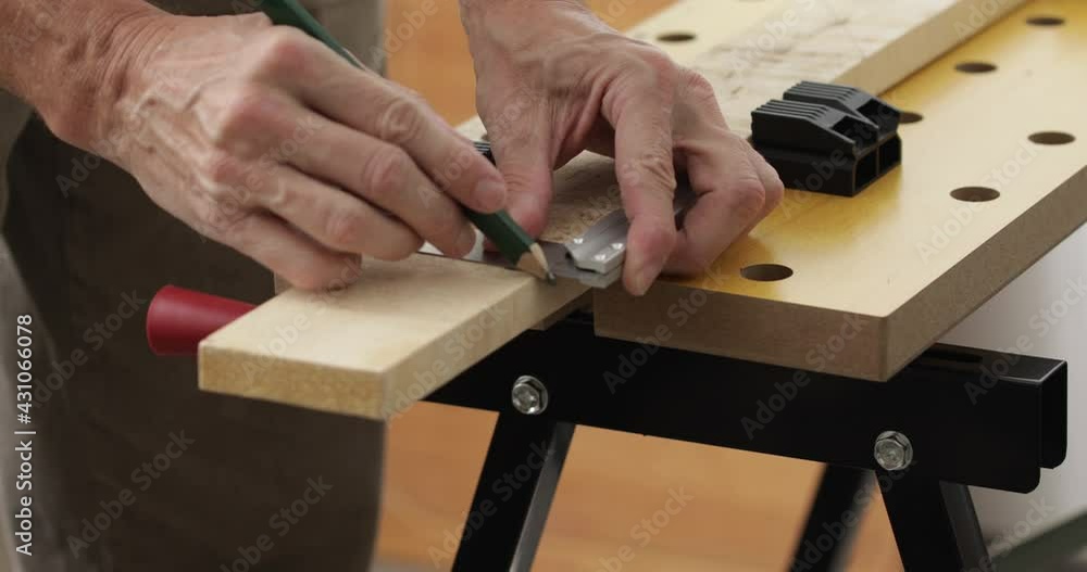 DIY woodworking, man drawing cutting lines at wood plank using square ruler and pencil, close up DIY woodworking, man drawing cutting lines at wood plank using square ruler and pencil, close up