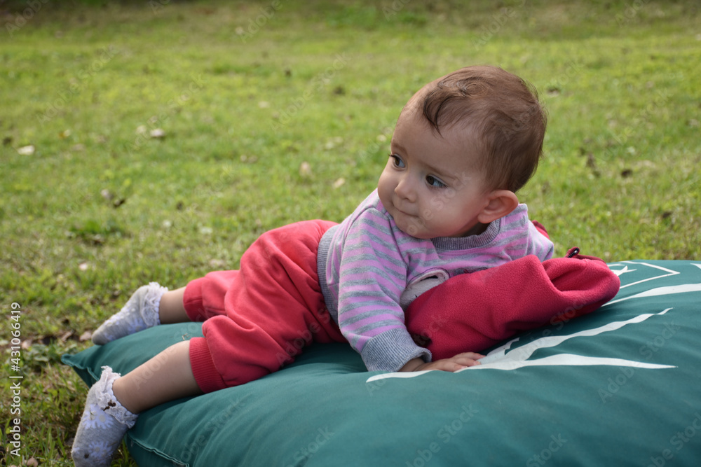 a laughing baby in nature lying on the ground a laughing baby in nature lying on the ground