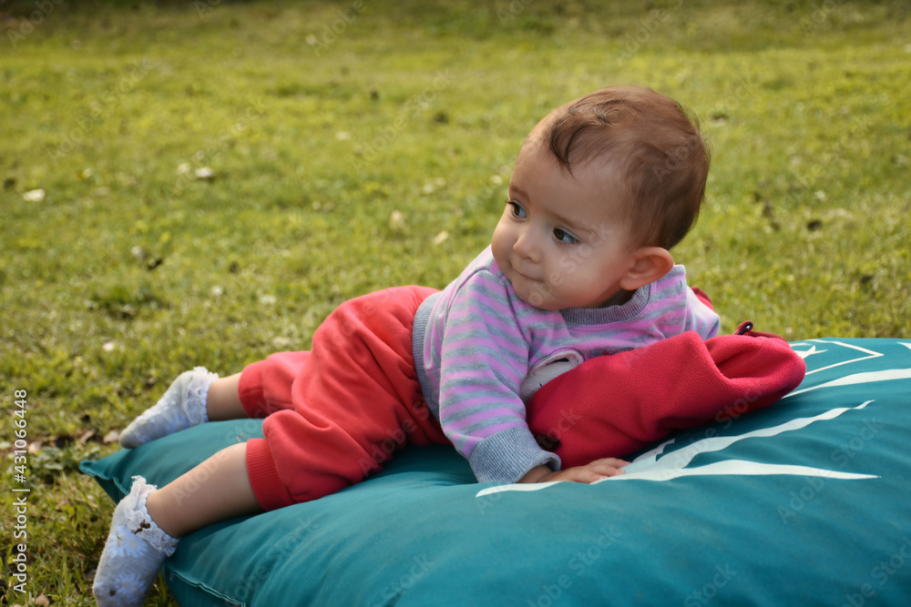 a laughing baby in nature lying on the ground a laughing baby in nature lying on the ground