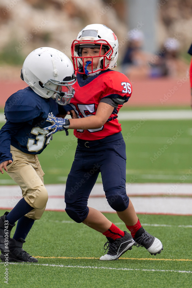 Young athletic boy playing in a youth tackle football game Young athletic boy playing in a youth tackle football game