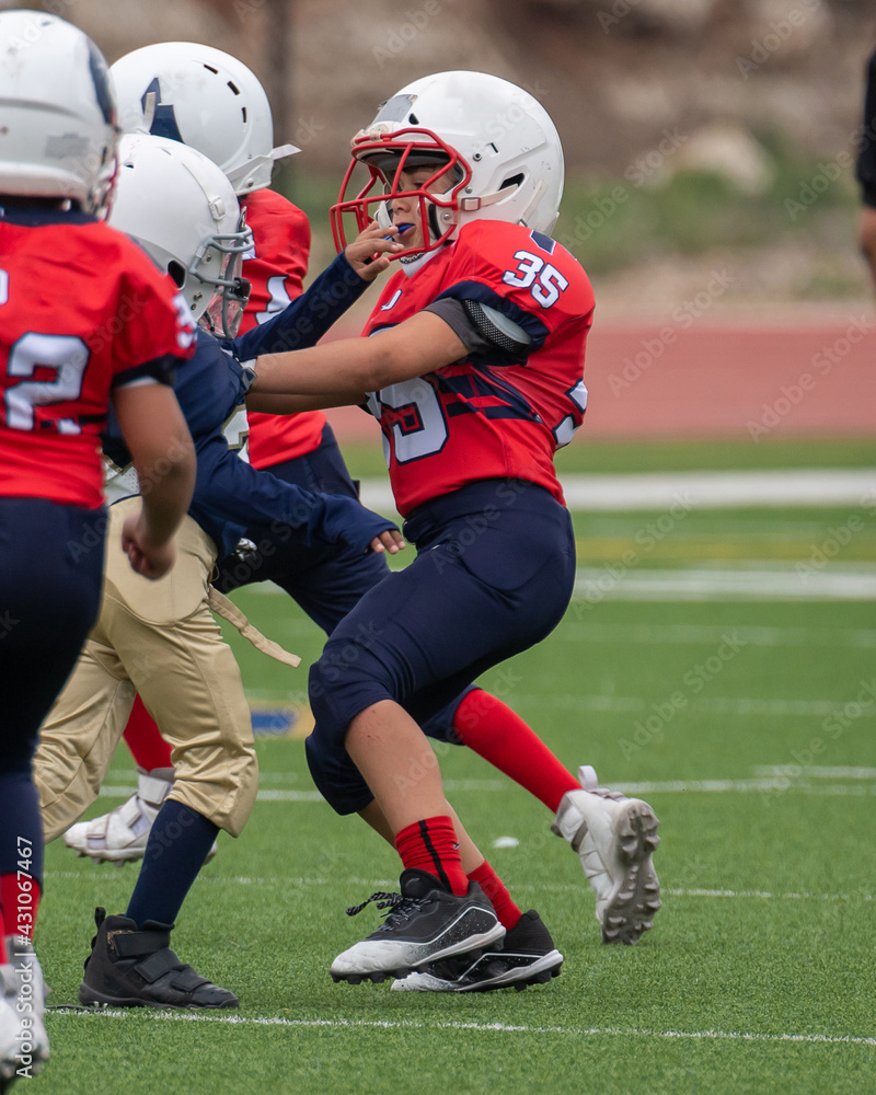 Young athletic boy playing in a youth tackle football game Young athletic boy playing in a youth tackle football game
