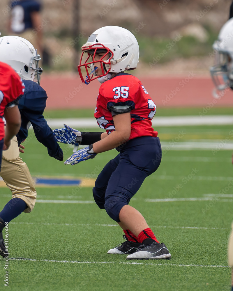 Young athletic boy playing in a youth tackle football game Young athletic boy playing in a youth tackle football game