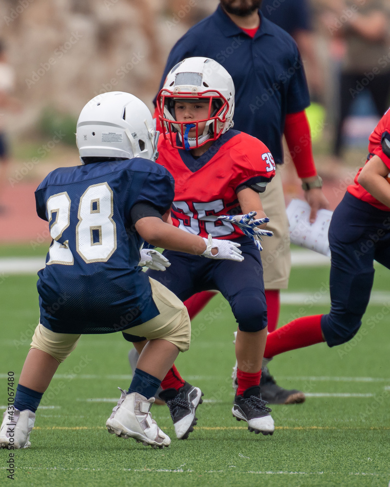 Young athletic boy playing in a youth tackle football game Young athletic boy playing in a youth tackle football game