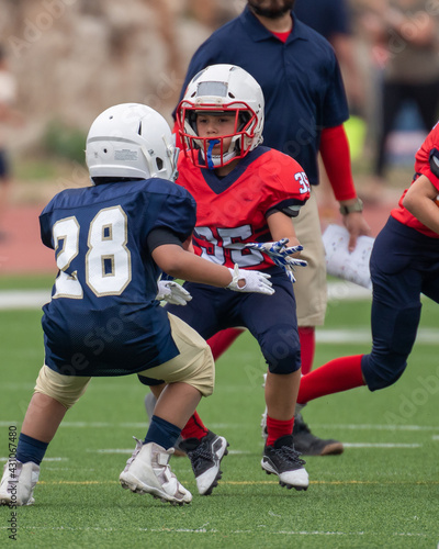 Young athletic boy playing in a youth tackle football game