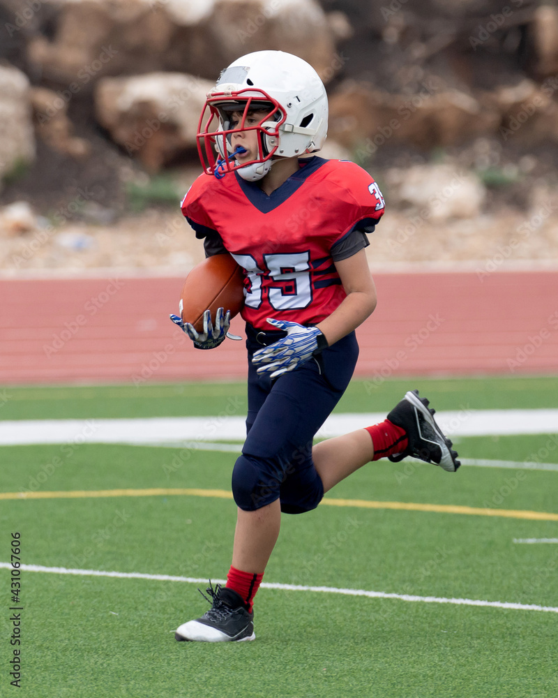Young athletic boy playing in a youth tackle football game Young athletic boy playing in a youth tackle football game