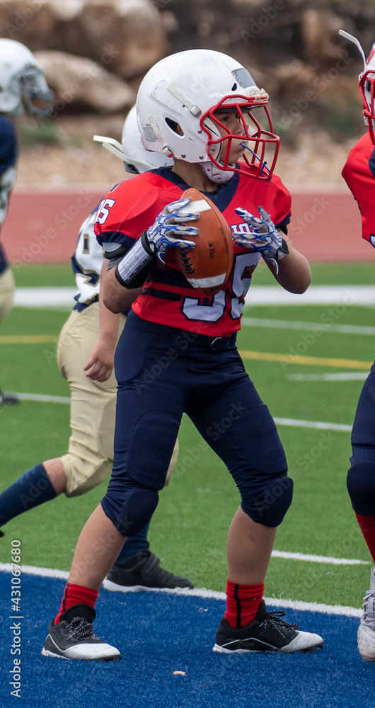 Young athletic boy playing in a youth tackle football game Young athletic boy playing in a youth tackle football game