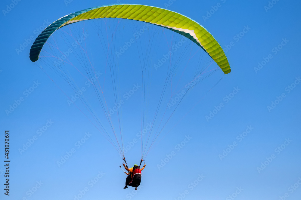 Cloudless photo of two people paragliding in blue sky Cloudless photo of two people paragliding in blue sky