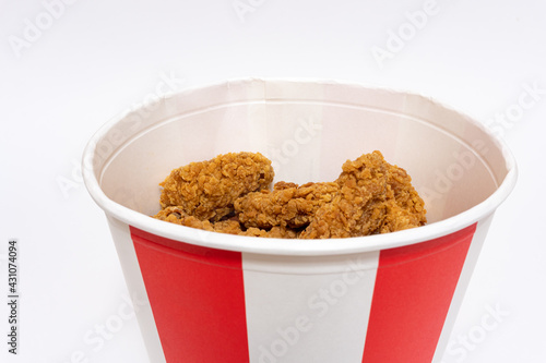 Deep fried spicy chicken wings in a crispy breading in a basket, chicken fast food isolated on white background