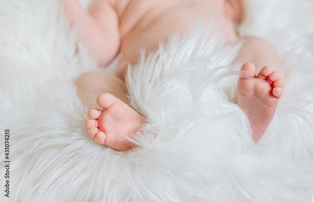 Tiny baby infant newborn feet toes at white fur fluffy blanket close up, cozy child sleeping, light background and tendet skin Tiny baby infant newborn feet toes at white fur fluffy blanket close up, cozy child sleeping, light background and tendet skin