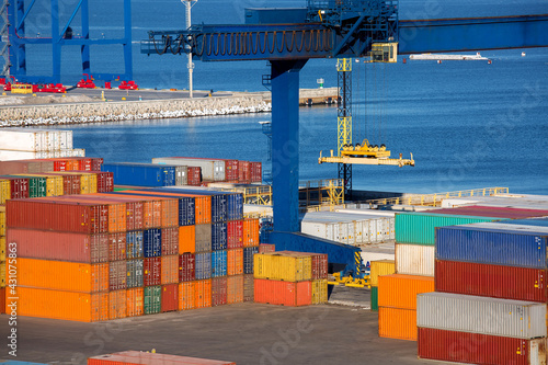 Canvas-taulu heavy lifting crane for unloading and sorting multi-colored containers at the seaport dock by the sea, nobody
