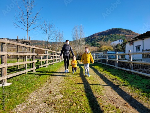 Excursión con críos a la granja de pueblo Ilundain Navarra España Madre con dos críos de paseo , 