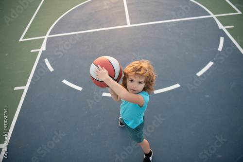 Little child boy playing basketball with basket ball. © Volodymyr